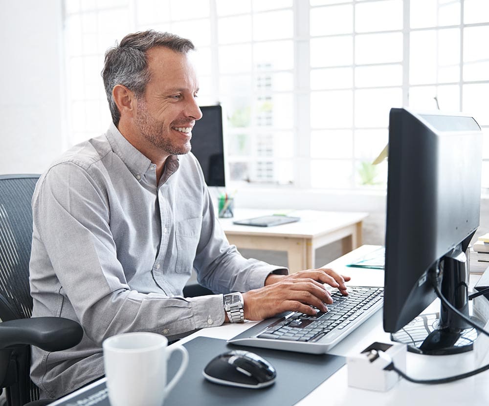 Man sitting at computer smiling